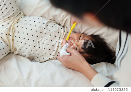 mother brushing her daughters teeth. crying baby with tooth brush mother brushing her daughters teeth. crying baby with tooth brush 115023826