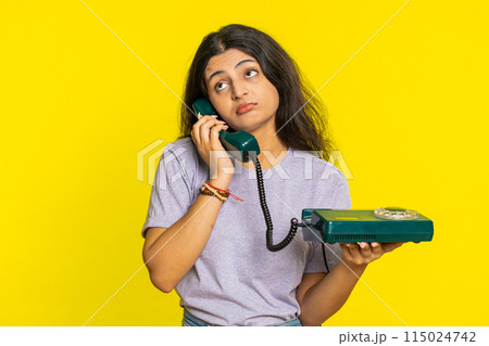 Tired bored woman talking on wired vintage telephone exhausted of talk, making silly faces, fooling Tired bored woman talking on wired vintage telephone exhausted of talk, making silly faces, fooling 115024742