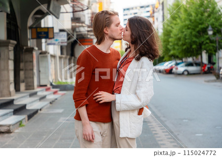 Side view of young Caucasian romantic couple man and woman kissing on street, arrange date. Valentine's Day. Concept of relationship psychology 115024772