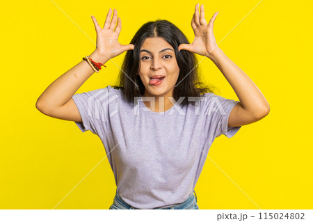 Cheerful funny bully Indian woman showing tongue making silly faces, fooling around, joking, teasing 115024802