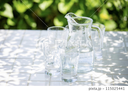 テラスで水分補給　木陰のテーブルのグラスとピッチャー 115025441