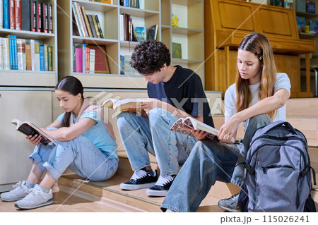 Teenage students sitting in college high school library reading books Teenage students sitting in college high school library reading books 115026241