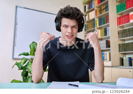 Web cam portrait of college student guy in headphones looking talking to camera Web cam portrait of college student guy in headphones looking talking to camera 115026284