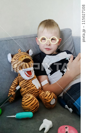 A boy brushes his teeth with a toy with an artificial jaw. Playing as a dentist, professional preparation of a child for the profession of a pediatric dentist. Hygiene and dental care 115027108
