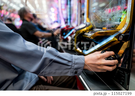 パチンコ台で遊戯する人々 115027199