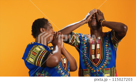 Cheerful african american couple laughing at thing in studio, having fun with jokes and being amused over background. Married ethnic people enjoying laugh on camera, joyful partners. Cheerful african american couple laughing at thing in studio, having fun with jokes and being amused over background. Married ethnic people enjoying laugh on camera, joyful partners. 115027203