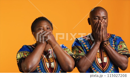 Ethnic couple doing three wise monkeys symbol on camera, showcasing sign to not hear, see or speak in studio. African american man and woman covering their eyes, mouth and ears. Ethnic couple doing three wise monkeys symbol on camera, showcasing sign to not hear, see or speak in studio. African american man and woman covering their eyes, mouth and ears. 115027208