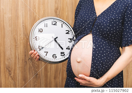 Pregnant Woman Holding Wall Clock Pregnant Woman Holding Wall Clock 115027902