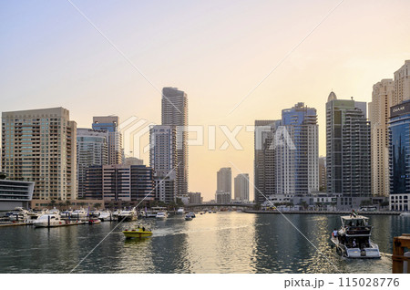 Sunset view of the canal, marina with boats, promenade and skyscrapers of Dubai, the Persian Gulf Sunset view of the canal, marina with boats, promenade and skyscrapers of Dubai, the Persian Gulf 115028776