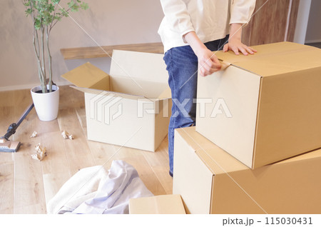 段ボールに荷物をまとめる女性 115030431