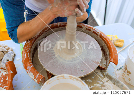 Working with wet soft clay on potters wheel, potter creates bowl 115037671