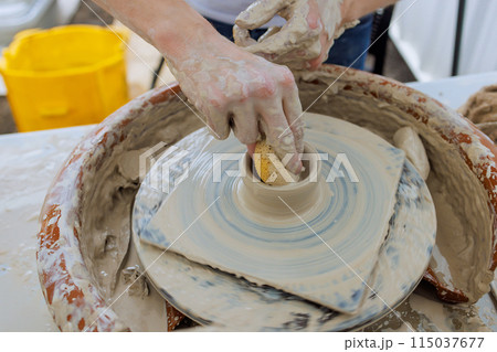 Professional potter worker creating bowl with wet soft clay using potter wheel Professional potter worker creating bowl with wet soft clay using potter wheel 115037677