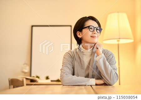 暖色の室内灯の部屋でリラックスした表情の女性 115038054