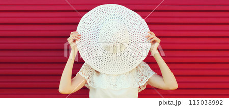 Beautiful young woman model posing in white summer straw hat 115038992