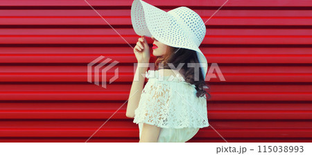 Beautiful young woman model posing in white summer straw hat Beautiful young woman model posing in white summer straw hat 115038993