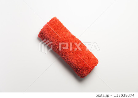 Fluffy orange-red rolled up towel on white background 115039374
