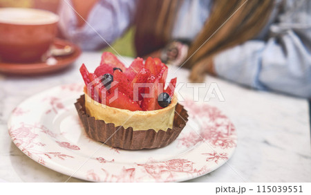 Young woman tasting strawberry-topped cake, Selective focus. Young woman tasting strawberry-topped cake, Selective focus. 115039551