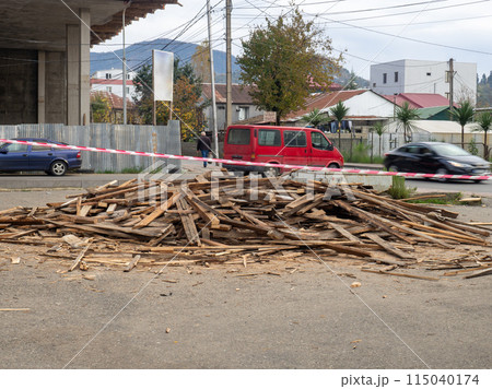 A pile of old boards lies on the street. Used building materials. Rubbish on the street A pile of old boards lies on the street. Used building materials. Rubbish on the street 115040174