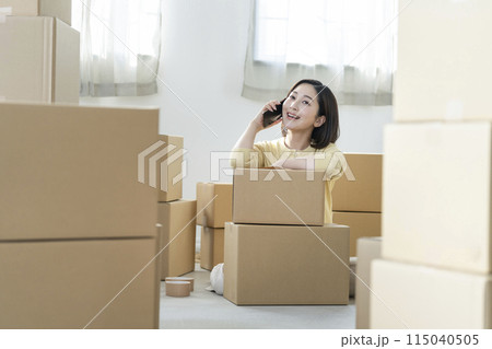 引越しイメージ　スマートフォンで通話する若い女性　 115040505