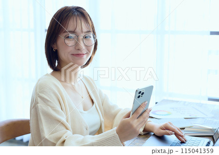 自宅でパソコンに向かって仕事をする女性デザイナー 115041359