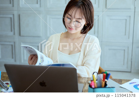 自宅でパソコンに向かって仕事をする女性デザイナー 115041378