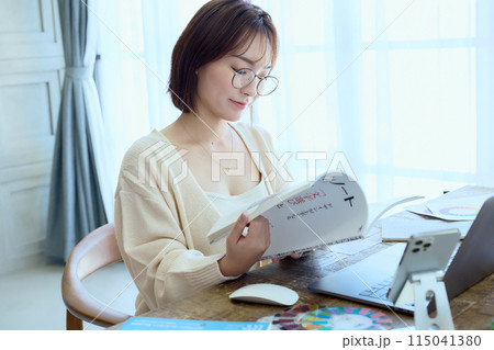 自宅でパソコンに向かって仕事をする女性デザイナー 115041380