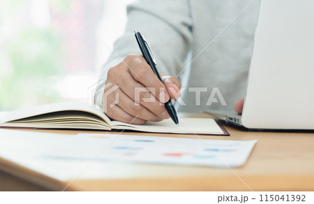 ペンを持つ男性の手元 115041392