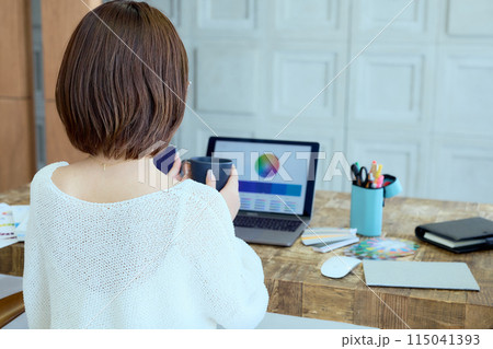 自宅でパソコンに向かって仕事をする女性デザイナー 115041393