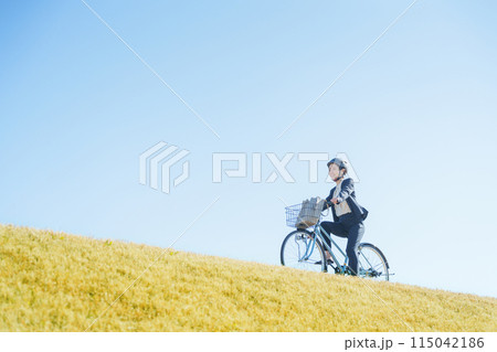 青空と自転車通勤するビジネスマン(ヘルメット) 青空と自転車通勤するビジネスマン(ヘルメット) 115042186