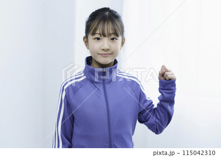 スポーツウェアを着てガッツポーズをとる小学生の女の子のポートレート スポーツウェアを着てガッツポーズをとる小学生の女の子のポートレート 115042310