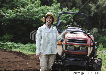 トラクターで畑を耕す女性 115043436