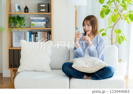 リビングでスマホを見る若い女性 リビングでスマホを見る若い女性 115044065
