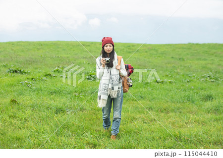 草原でカメラを構える女性 115044410