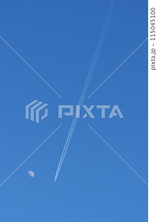 青空に浮かぶ白い月とひこうき雲 115045100