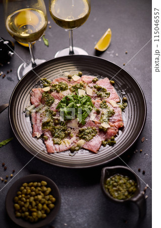 tuna carpaccio - slices of fresh raw tuna fillet on black ceramic plate tuna carpaccio - slices of fresh raw tuna fillet on black ceramic plate 115046557