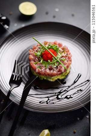 Tuna and avocado tartare on a dark ceramic plate Tuna and avocado tartare on a dark ceramic plate 115046561