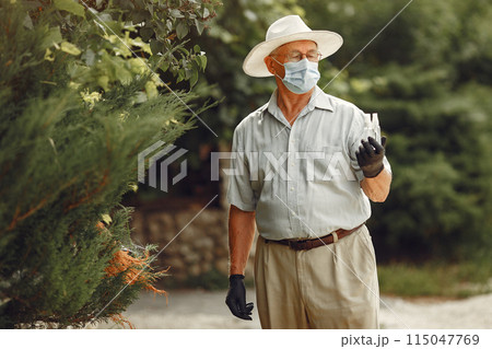 Old man in a medical mask. Man in the park. Coronavirus theme. Old man in a medical mask. Man in the park. Coronavirus theme. 115047769
