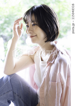 ラフな服装でくつろぐフェミニンな雰囲気の若い女性 115048316