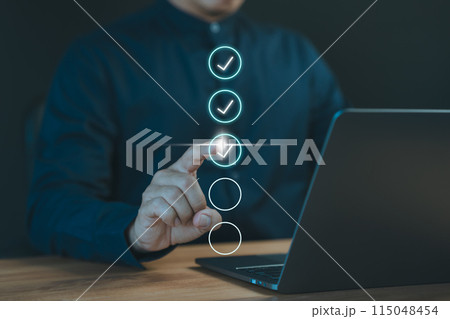 Concept of compliance to regulations product, Service, Quality control, Inspection, Standardization, certification. Businessman use a laptop computer to tick correct sign mark in checkbox. 115048454