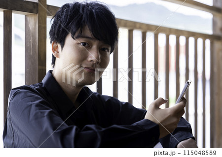ベランダでスマホを使う若い男性 ベランダでスマホを使う若い男性 115048589