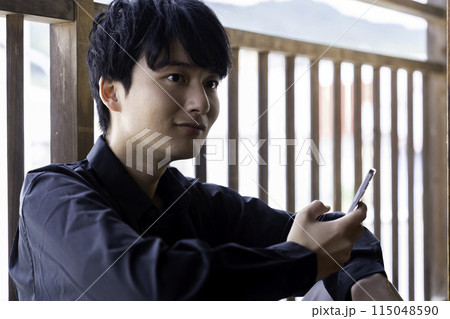 ベランダでスマホを使う若い男性 ベランダでスマホを使う若い男性 115048590