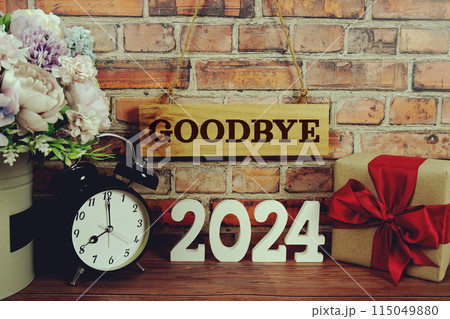 Goodbye 2024 letters with alarm clock and gift box on wooden background Goodbye 2024 letters with alarm clock and gift box on wooden background 115049880