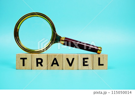 Travel with wooden blocks alphabet letters and Magnifying glass on blue background 115050014