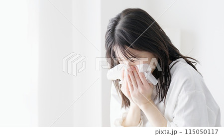 部屋で鼻をかむ女性 115050117