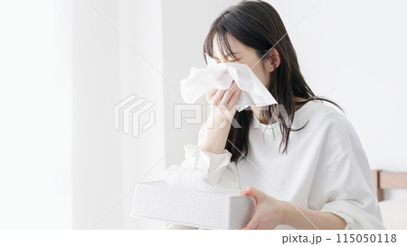 部屋で鼻をかむ女性 115050118