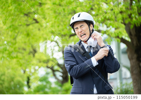 汗を拭うヘルメットをかぶったビジネスマン 汗を拭うヘルメットをかぶったビジネスマン 115050199