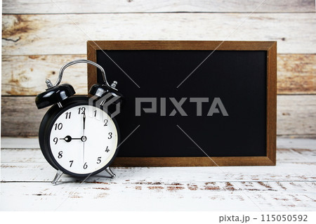 Chalkboard and alarm clock for text message copy on wooden background 115050592