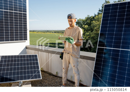 Technician with a digital tablet on a rooftop with solar power station Technician with a digital tablet on a rooftop with solar power station 115050814