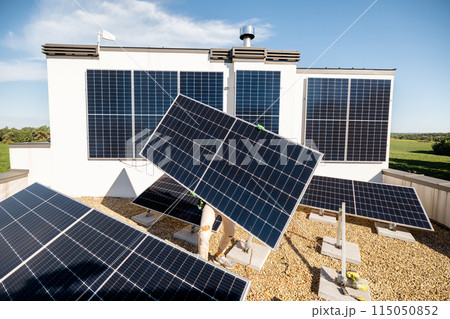 Man installing solar panels on a rooftop 115050852