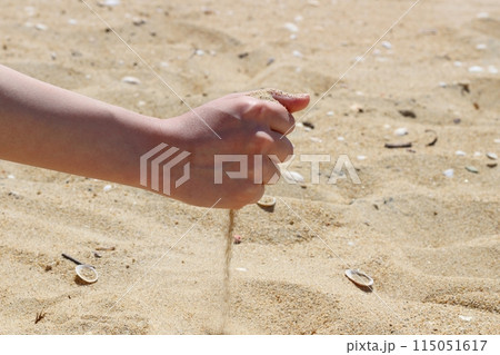 砂浜で砂を持つ手　手の中の砂が落ちていく様子 115051617